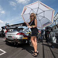 Sexy grid girl next to supercar on grid of motorsport track